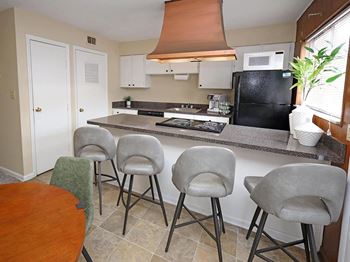 Kitchen island with electric stove and overhead copper exhaust fan